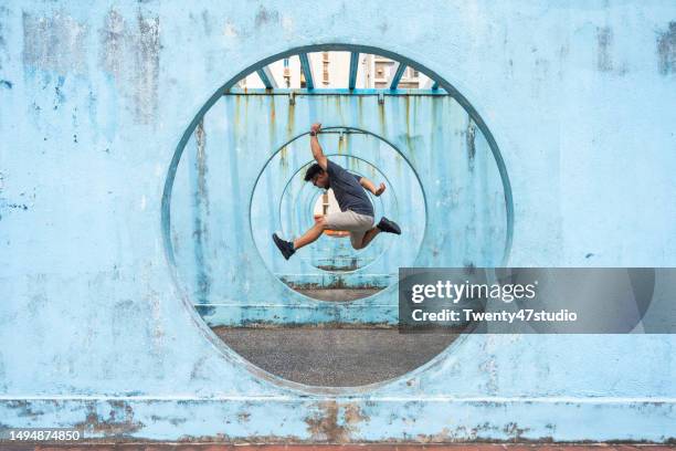 a man jumping inside a circle shaped structure in lok wah estate in hong kong - isla de hong kong fotografías e imágenes de stock