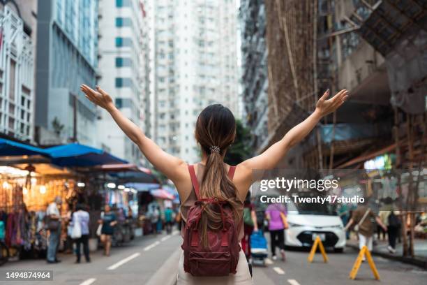 rear view of woman enjoys journey in hong kong street - wet market stock pictures, royalty-free photos & images