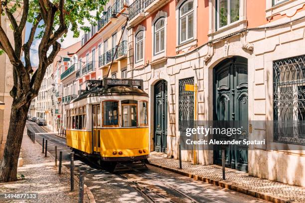 old yellow tram on the streets of lisbon old town on a sunny day, portugal - provincie lissabon stockfoto's en -beelden