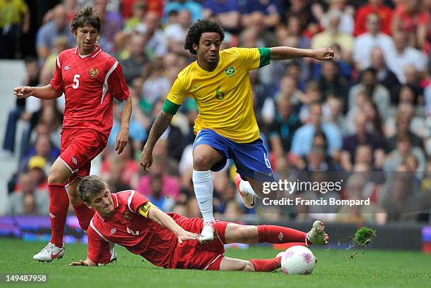 Marcelo of Brazil evades the challenge of Stanislav Dragun of Belarus during the Men's Football first round Group C Match between Brazil and Belarus...