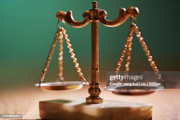 selective focus of libra scale on table top against chalkboard - justizsystem stock-fotos und bilder