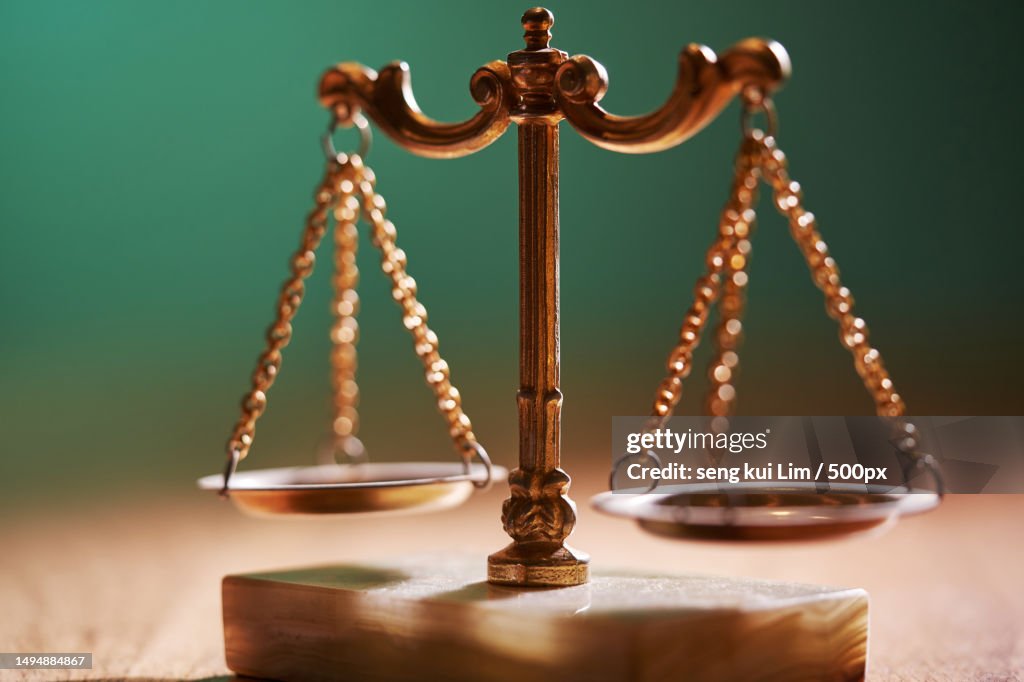 Selective focus of libra scale on table top against chalkboard
