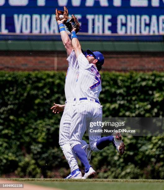 Patrick Wisdom of the Chicago Cubs collides with Dansby Swanson after catching a fly out by Brandon Lowe of the Tampa Bay Rays during the second...