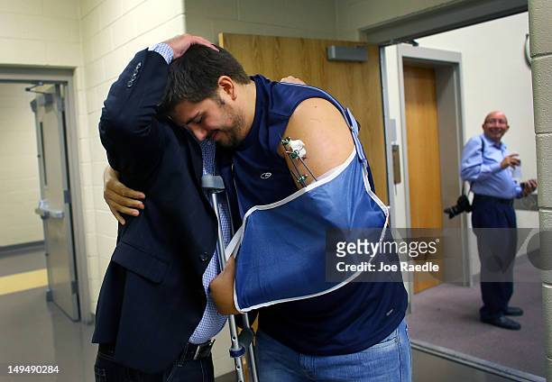 Pierce O'Farrill who was wounded during the Century 16 movie theater shooting receives a hug from Chad Weinmaster as he attends a service at The Edge...
