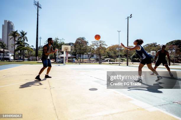 des amis jouent au basketball sur un terrain de sport - match basket photos et images de collection