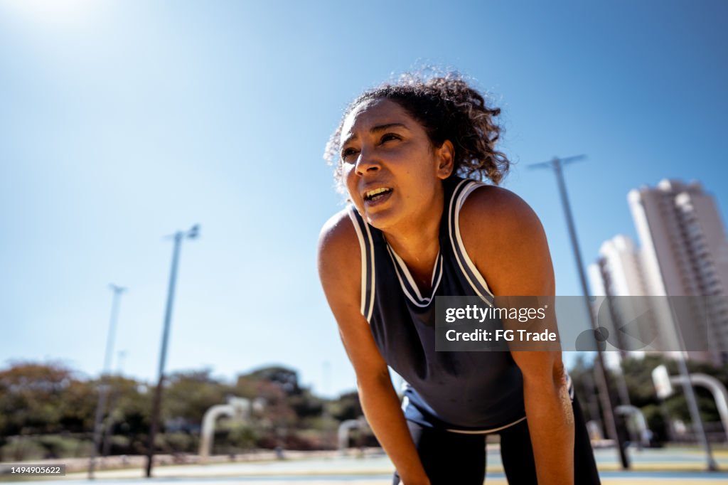 Mulher adulta média olhando para longe durante exercícios ao ar livre