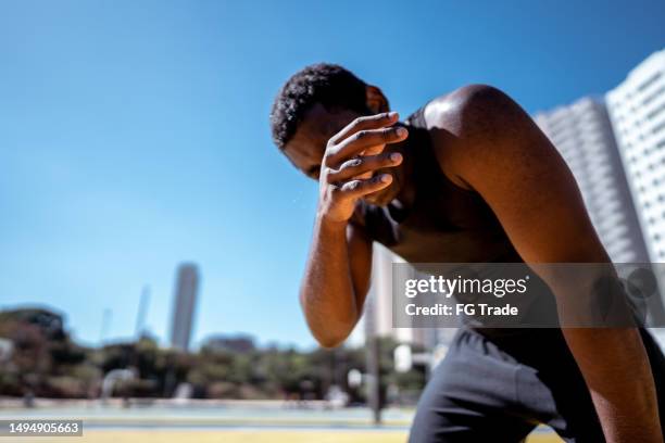 tired young man during exercises outdoors - sportman stockfoto's en -beelden