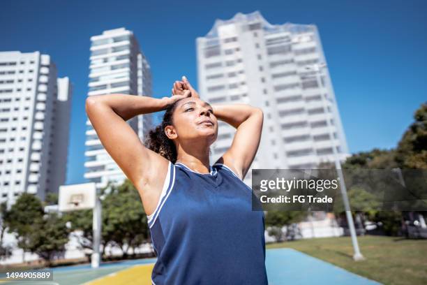 mid adult woman breathing after play basketball on a sport court - practice gratitude stock pictures, royalty-free photos & images