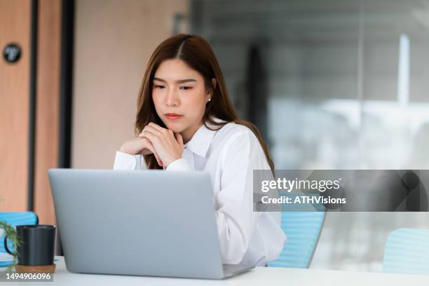 businesswoman using laptop and making decision of work at office. - female likeness stock pictures, royalty-free photos & images