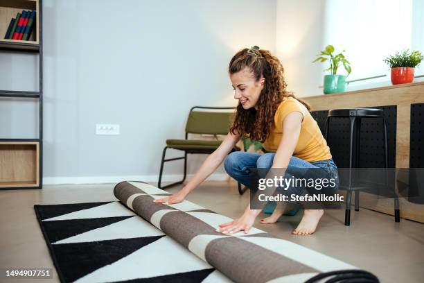 housewife rolls the carpet - carpet rolls imagens e fotografias de stock