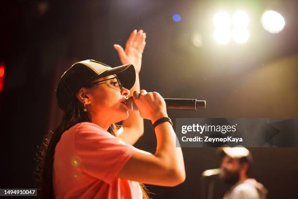 musician singing with microphone on stage - rapper stock pictures, royalty-free photos & images