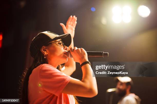 musician singing with microphone on stage - nas rapper imagens e fotografias de stock