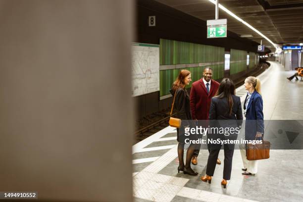 business people waiting a train in a subway platform after work. - metrostation stockfoto's en -beelden