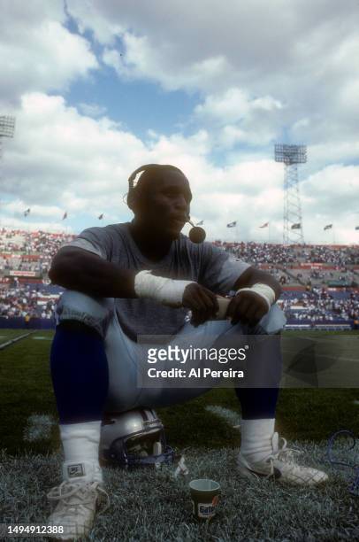 Running Back Barry Sanders of the Detroit Lions sits on his helmet and conducts a post-game interview after the game between the Detroit Lions vs the...
