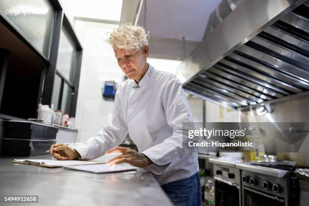 chef working at a restaurant and creating a menu - commercial kitchen and ingredients stock pictures, royalty-free photos & images