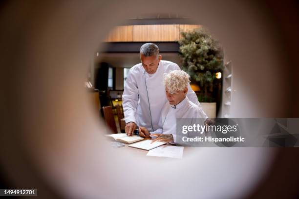 business partners doing the books at a restaurant - bistro stock pictures, royalty-free photos & images