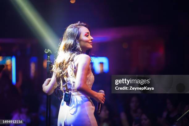 musiker auf der bühne singt mit mikrofon vor überfülltem publikum - boygroup stock-fotos und bilder