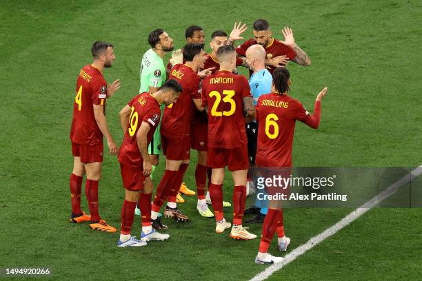 Players of AS Roma confront Referee Anthony Taylor after a penalty is awarded to Sevilla FC, which is later overturned following a Video Assistant...