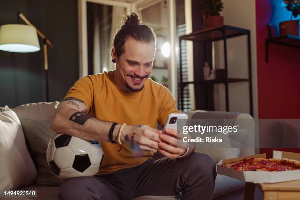 man using a mobile phone during a soccer match - bet stock pictures, royalty-free photos & images