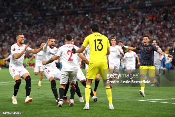 Gonzalo Montiel celebrates with Yassine Bounou of Sevilla FC after scoring the sides fourth and winning penalty in the penalty shoot out during the...