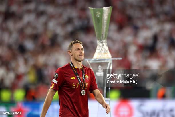 Nemanja Matic of AS Roma walks past the UEFA Europa League Trophy with their runners up medal following their side's defeat to Sevilla FC in the...