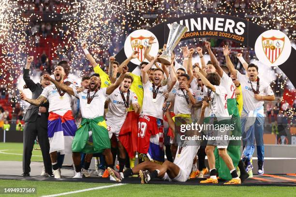 Ivan Rakitic and Jesus Navas of Sevilla FC lift the UEFA Europa League trophy after the team's victory during the UEFA Europa League 2022/23 final...