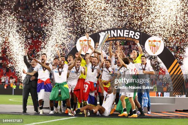 Ivan Rakitic and Jesus Navas of Sevilla FC lift the UEFA Europa League trophy after the team's victory during the UEFA Europa League 2022/23 final...