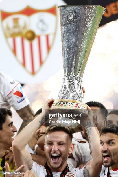 Ivan Rakitic and Jesus Navas of Sevilla FC lift the UEFA Europa League trophy after the team's victory during the UEFA Europa League 2022/23 final...