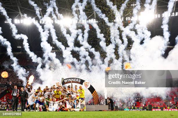 Ivan Rakitic and Jesus Navas of Sevilla FC lift the UEFA Europa League trophy after the team's victory during the UEFA Europa League 2022/23 final...