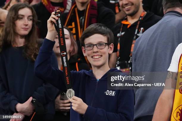 Fan poses for a photograph with Jose Mourinho's, Head Coach of AS Roma, runners up medal, during the UEFA Europa League 2022/23 final match between...