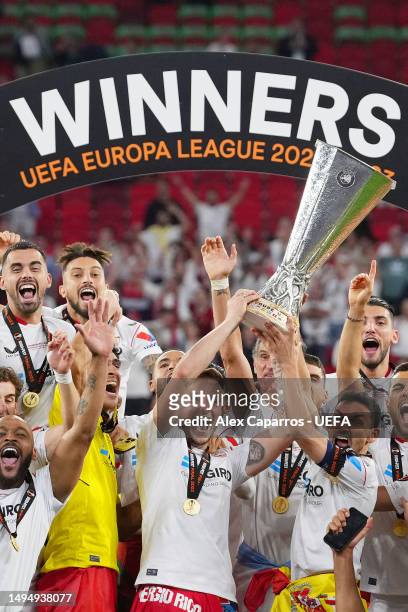 Ivan Rakitic and Jesus Navas of Sevilla FC lift the UEFA Europa League trophy after the team's victory during the UEFA Europa League 2022/23 final...