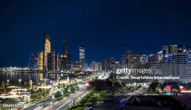 abu dhabi skyline illuminated at night in abu dhabi, united arab emirates - abu dhabi city stock pictures, royalty-free photos & images