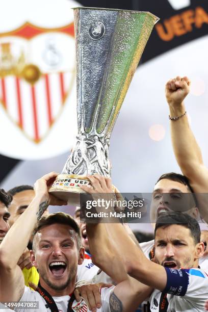 Ivan Rakitic and Jesus Navas of Sevilla FC lift the UEFA Europa League trophy after the team's victory during the UEFA Europa League 2022/23 final...