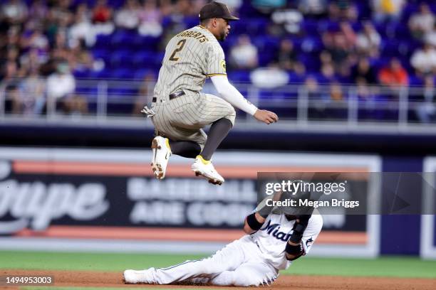 Luis Arraez of the Miami Marlins slides under Xander Bogaerts of the San Diego Padres during the fourth inning at loanDepot park on May 31, 2023 in...