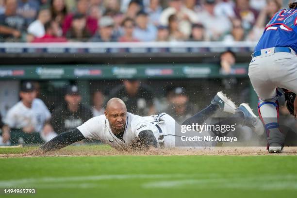 Jonathan Schoop of the Detroit Tigers slides home against Jonah Heim of the Texas Rangers during the bottom of the fifth inning at Comerica Park on...