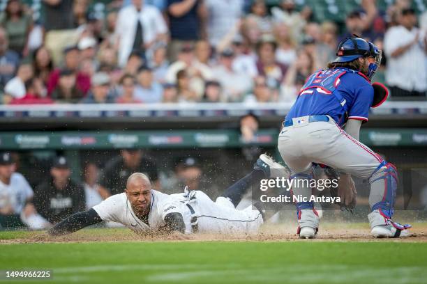 Jonathan Schoop of the Detroit Tigers slides home against Jonah Heim of the Texas Rangers during the bottom of the fifth inning at Comerica Park on...