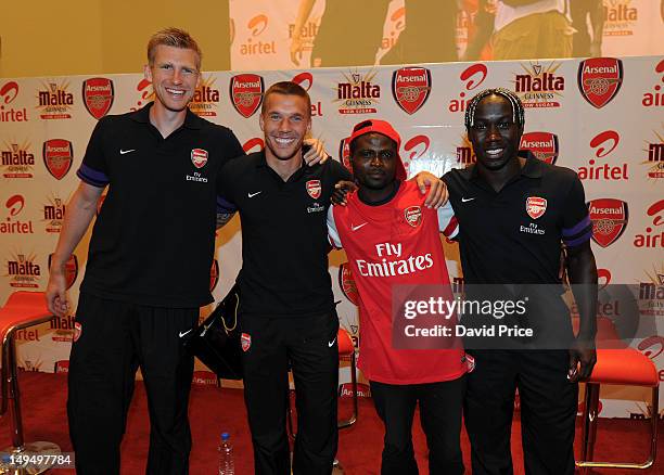 Per Mertesacker , Lukas Podolski and Bacary Sagna of Arsenal FC pose with a fan at an Arsenal Fans Party at the Eko Hotel on July 29, 2012 in Lagos,...