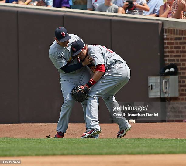 Allen Craig and Tyler Greene of the St. Louis Cardinals collide while trying to make a play against the Chicago Cubs at Wrigley Field on July 29,...