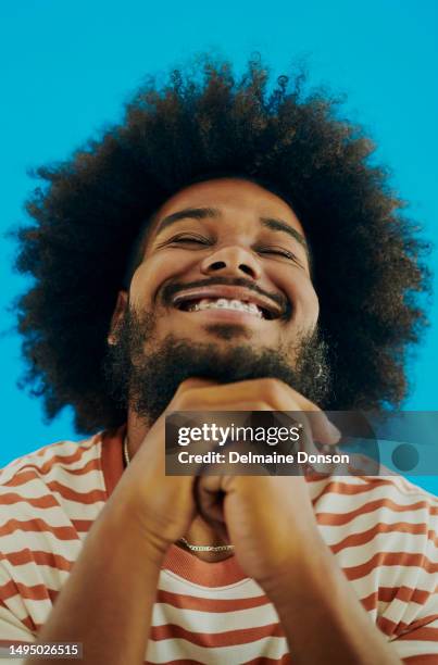 junger schwarzer mann lächelt, während sein kopf nach hinten gebeugt und die augen geschlossen sind, die hände unter dem kinn verschränkt. stockfotografie - man looking up beard chin stock-fotos und bilder