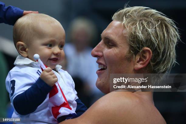 Jesse Smith of the United States celebrates winning the Men's Water Polo Preliminary Round Group B match against Montenegro with his son Brook on Day...