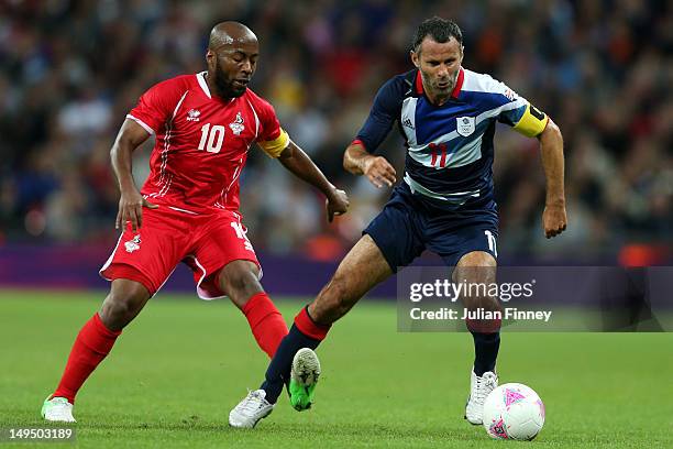 Ryan Giggs of Great Britain tangles with Ismail Matar of United Arab Emirates during the Men's Football first round Group A Match between Great...