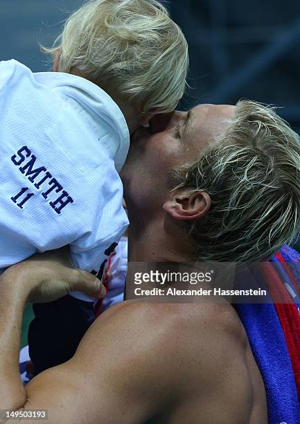 Jesse Smith of the United States celebrates winning the Men's Water Polo Preliminary Round Group B match against Montenegro with his son on Day 2 of...
