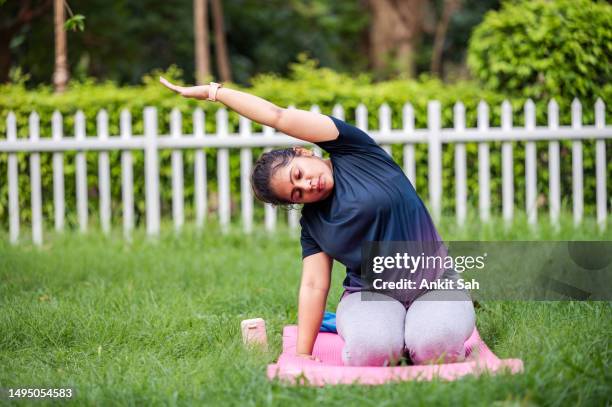 young woman doing yoga and meditation at park - yoga day stock pictures, royalty-free photos & images