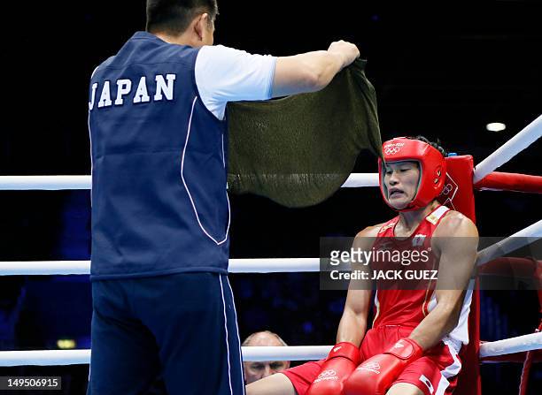 Yasuhiro Suzuki of Japan cools off in his corner en route to a close 14-13 points decision victory over Mehdi Khalsi of Morocco in their first round...