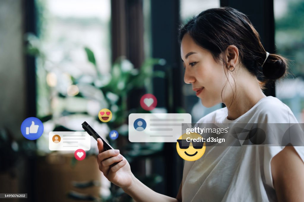Young Asian woman using smartphone on social media network application. Viewing posts, giving likes or love, making friends on social media pages in the city. People engaging in networking with technology. Social media addiction concept