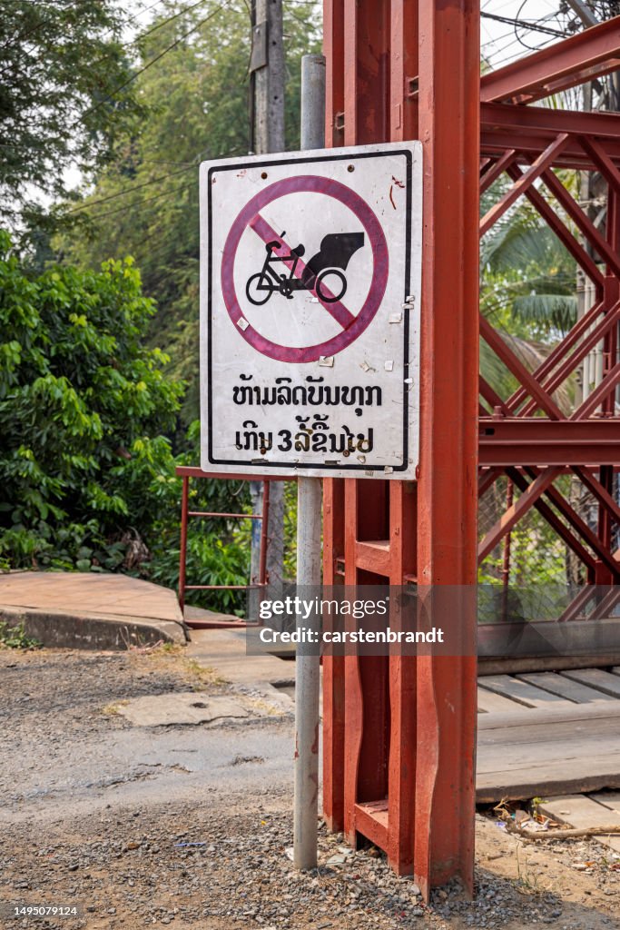 No rickshaw sign on a old wooden bridge crossing a river