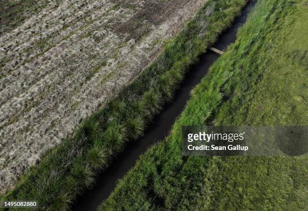 In this aerial view the channeled Sernitz creek flows between rewetted and a dry, agricultural tract of the Sernitzmoor peatland on May 31, 2023 near...
