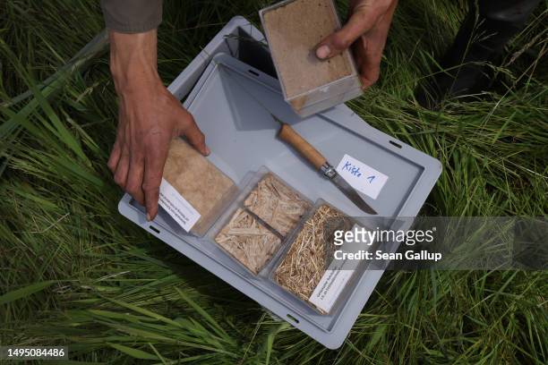 Fabian Frucht, a land manager of the Succow Stiftung foundation, holds boxes containing samples of commercial materials made from marsh-based plants...