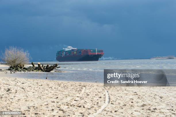 container ship on the elbe - beach sign stock pictures, royalty-free photos & images