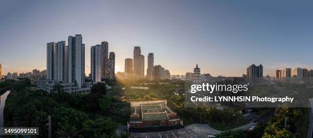 golden sunbeam split on the haikou mingchang tower and guan gong temple panorama - lynnhsin stock-fotos und bilder